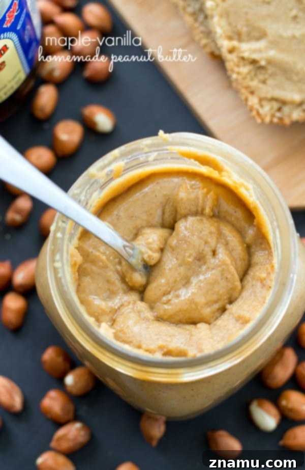 Maple Vanilla Peanut Butter Perfection 2 A jar of smooth, creamy homemade maple vanilla peanut butter on a wooden surface.