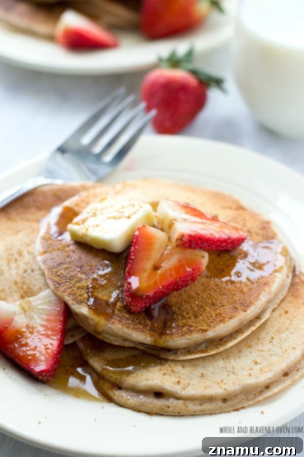 Close-up of golden brown snickerdoodle pancakes stacked high, showcasing their fluffy texture and enticing cinnamon sugar topping.