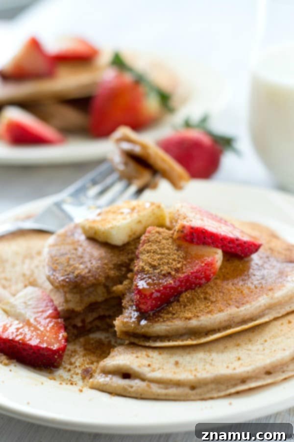 A stack of perfectly cooked snickerdoodle pancakes on a plate, ready to be enjoyed with a drizzle of syrup, highlighting their inviting aroma.