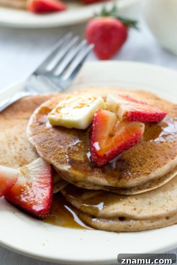 A side view of a towering stack of snickerdoodle pancakes, demonstrating their impressive height and inviting golden-brown crust.