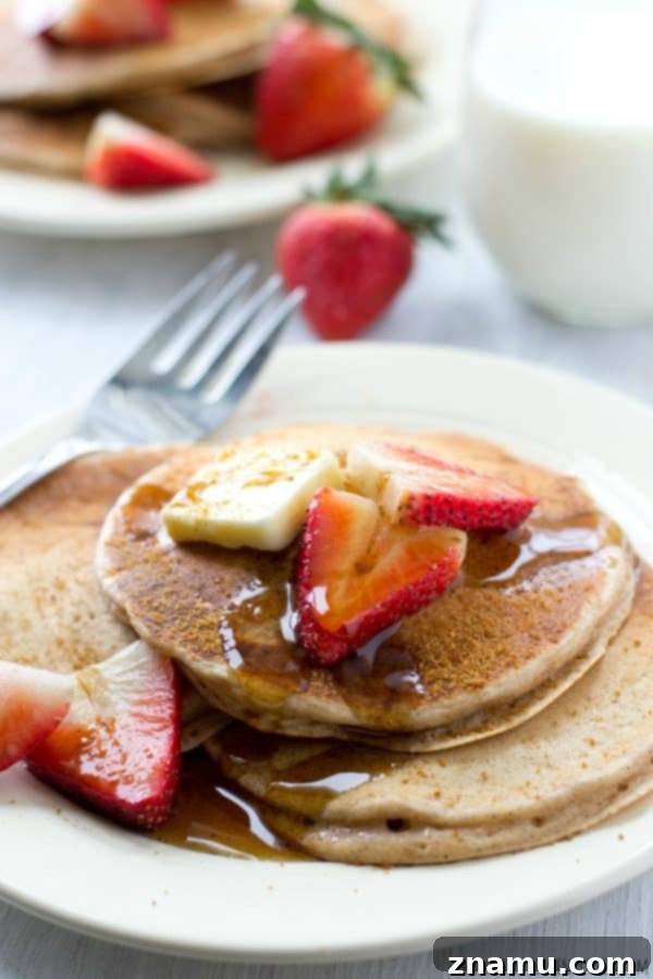 A single snickerdoodle pancake on a plate, featuring its soft, airy interior and generous dusting of cinnamon sugar.