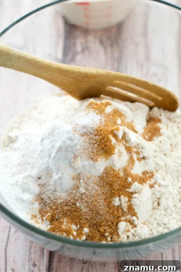 Dry ingredients like white whole wheat flour, baking powder, and baking soda, perfectly measured for the biscuit recipe.