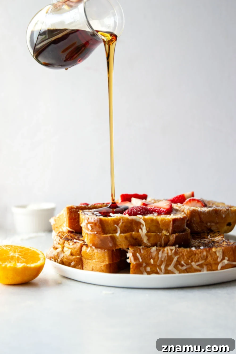 Tropical Coconut French Toast 4 Coconut Stuffed French Toast slices on a plate with fresh orange zest