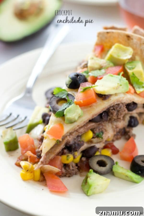 Slow Cooker Enchilada Bake 2 Delicious stacked crockpot enchilada pie with melted cheese, ready to be served