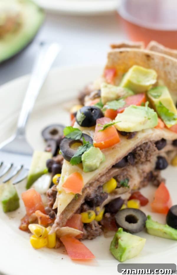 Slow Cooker Enchilada Bake 8 A serving of crockpot enchilada pie with melted cheese, topped with fresh avocado and cilantro