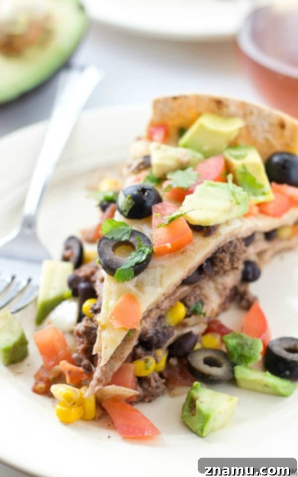 Slow Cooker Enchilada Bake 10 Another view of a generous slice of crockpot enchilada pie, garnished and ready to eat