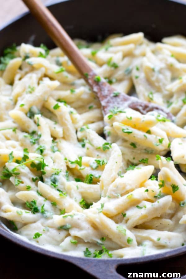 Quick Creamy Cauliflower Pasta Alfredo 4 A close-up of the delicious and healthy cauliflower pasta Alfredo, garnished with fresh herbs. @WholeHeavenly