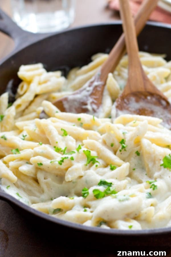 Quick Creamy Cauliflower Pasta Alfredo 8 Pasta Alfredo made with cauliflower sauce, garnished with fresh parsley for a vibrant touch. @WholeHeavenly