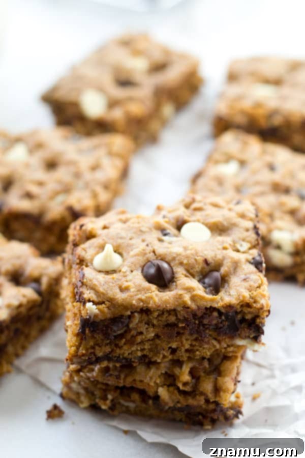Irresistibly Soft Chewy Blondies 3 Close-up of a perfectly baked blondie, showcasing its golden-brown crust and soft, gooey interior filled with chocolate chunks and nuts.