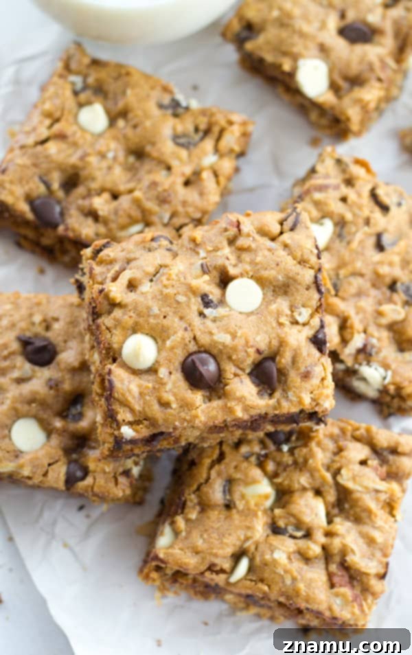 Irresistibly Soft Chewy Blondies 4 A stack of freshly baked, incredibly chewy blondies on a cooling rack, glistening with melted chocolate chips.