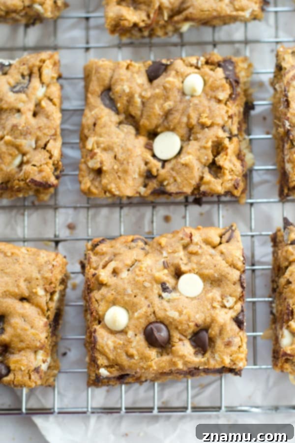 Irresistibly Soft Chewy Blondies 5 Homemade blondies cooling on a wire rack, showcasing their golden hue and the generous amount of mix-ins.
