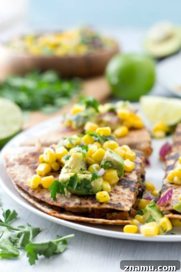Crispy Beef and Bean Quesadillas served with a side of refreshing Corn-Avocado Salsa on a wooden board