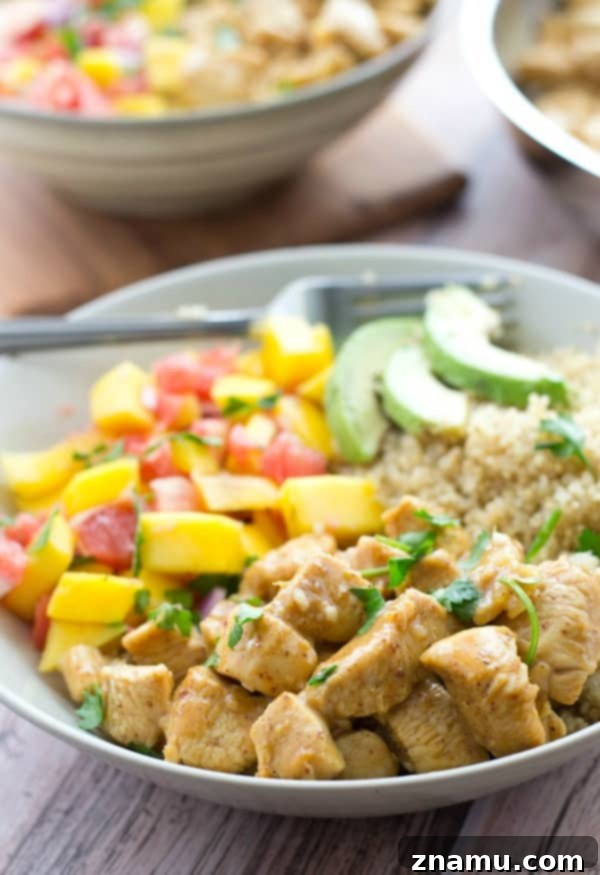 Zesty Honey Mustard Chicken Quinoa Bowls with Tropical Salsa 3 Two generously portioned quinoa bowls featuring honey mustard chicken, colorful mango salsa, and fresh cilantro