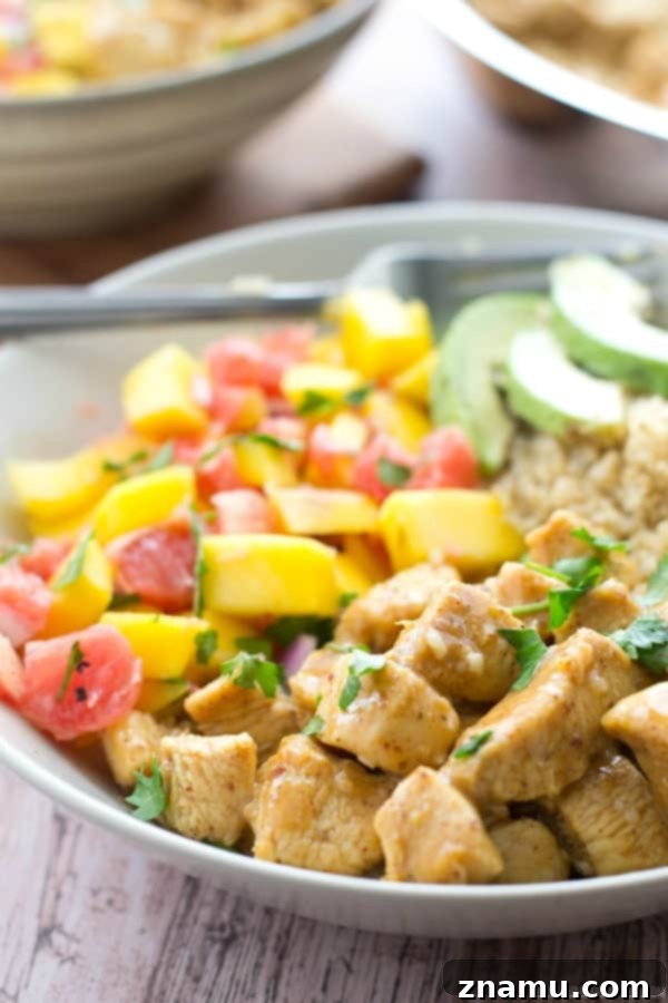 Zesty Honey Mustard Chicken Quinoa Bowls with Tropical Salsa 4 A top-down view of a single honey mustard chicken quinoa bowl, showcasing the generous toppings and fresh ingredients