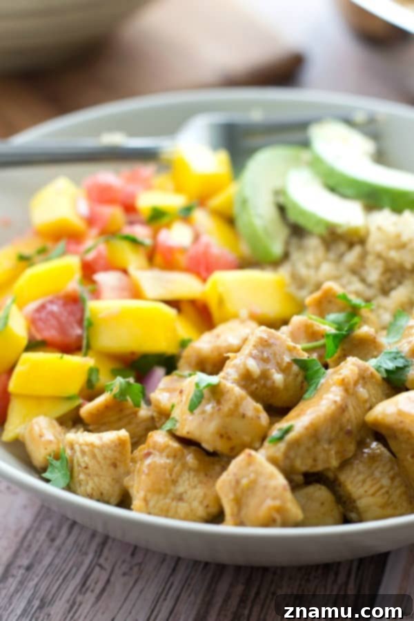 Zesty Honey Mustard Chicken Quinoa Bowls with Tropical Salsa 7 Two vibrant honey mustard chicken quinoa bowls on a light wooden surface, ready to be enjoyed