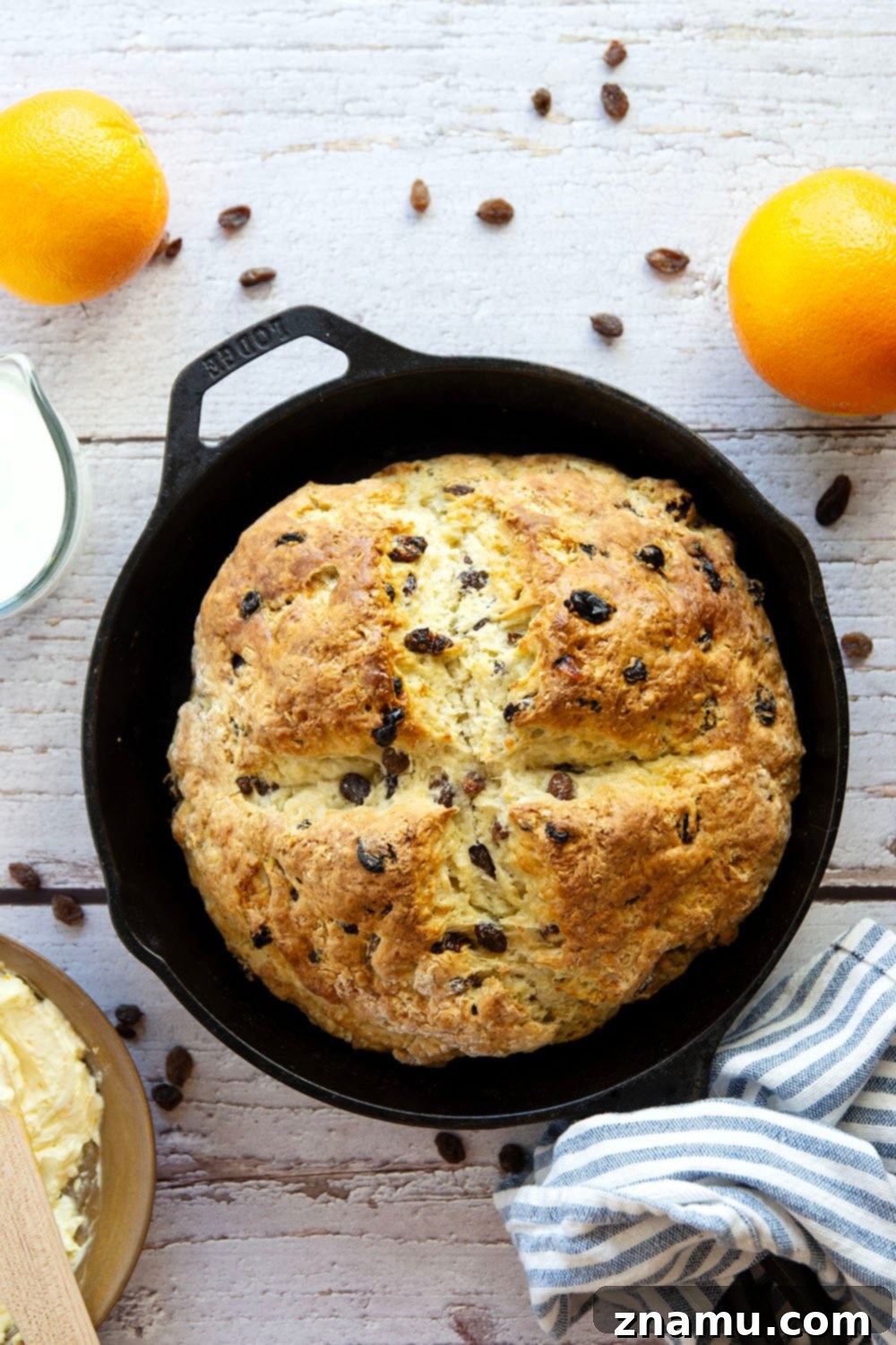 Sunshine Orange Irish Soda Bread with Cream Cheese 3 Close-up of a slice of Irish soda bread, showing its tender crumb and raisins, ready to be spread with orange cream cheese.