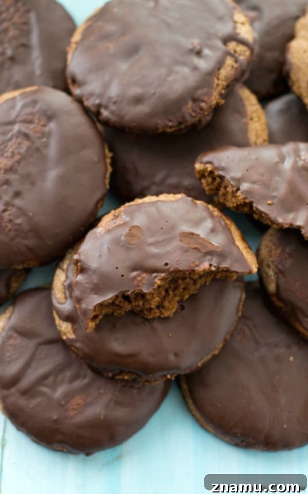 Grain-Free Mint Chocolate Wafers 4 A hand holding a freshly baked Paleo Thin Mint, highlighting its perfect round shape and dark chocolate glaze.