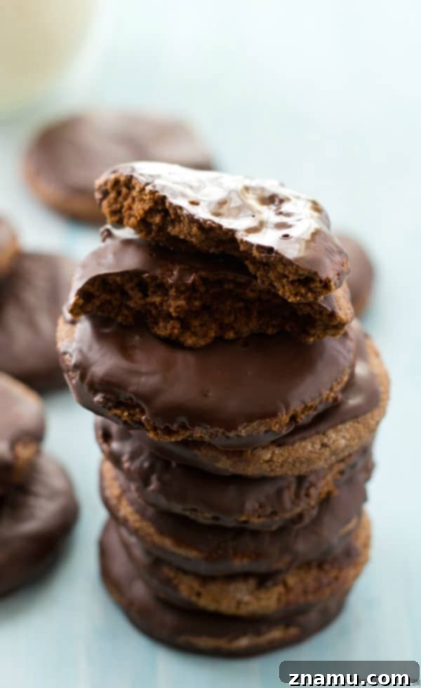 Grain-Free Mint Chocolate Wafers 6 A collection of perfectly coated Paleo Thin Mints, showing off their glossy, dark chocolate finish, arranged artfully on a white surface.