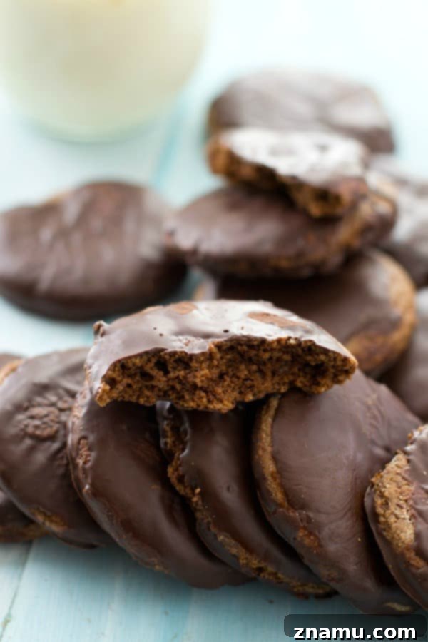 Grain-Free Mint Chocolate Wafers 7 A vibrant green background with a tall stack of homemade Paleo Thin Mints, showcasing their perfect layers and inviting appearance.