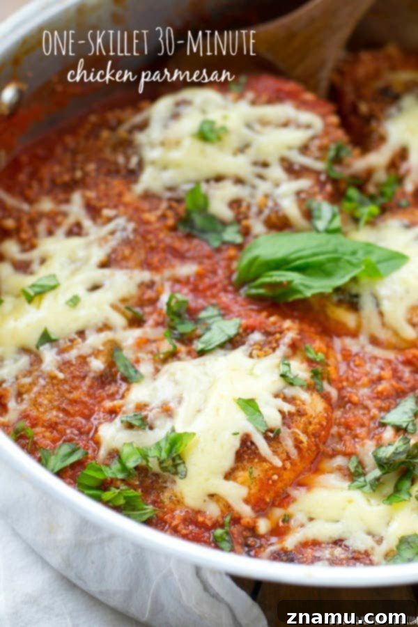 30-Minute One-Pan Chicken Parmesan 2 A golden-brown chicken cutlet smothered in rich tomato sauce and bubbling mozzarella cheese, fresh basil on top, in a rustic cast iron skillet, ready to serve.