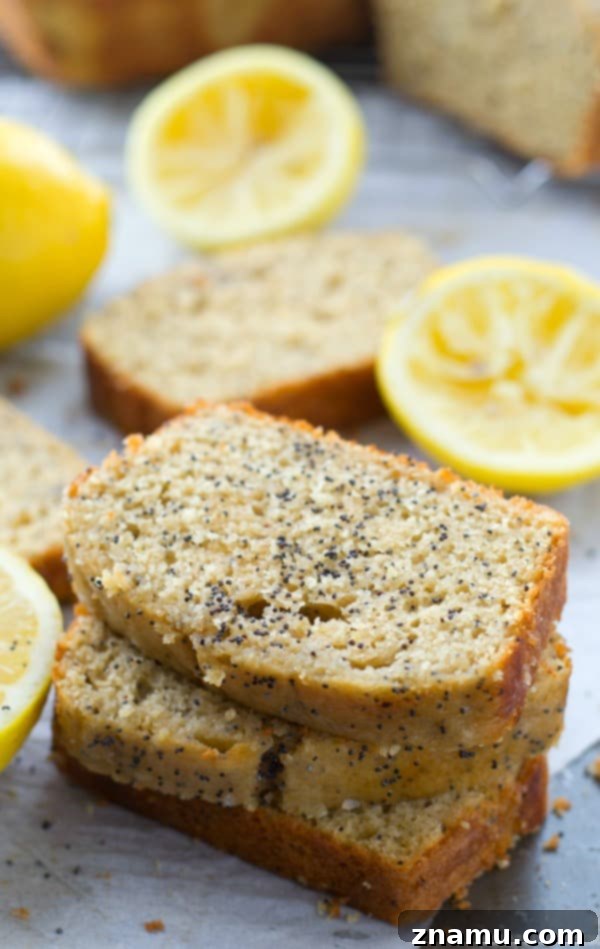 Zesty Poppy Drizzle Loaf 5 A close-up of the moist interior and poppy seeds within a slice of Glazed Lemon Poppy Seed Bread, revealing its tender crumb.