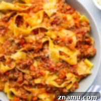 This slow cooker Bolognese features tender browned meat in a rich tomato sauce that's slow cooked for hours to build flavor. Toss this hearty sauce with tender pappardelle pasta and top with fresh Parmesan.