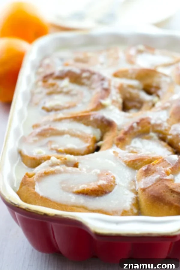 Irresistible Orange Cinnamon Rolls for Spring Bright and cheerful orange cinnamon rolls, perfectly swirled and topped with generous cream cheese icing, ready for a delightful spring brunch.