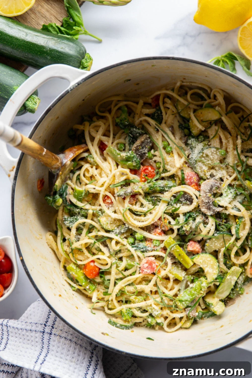 Vibrant Garden Pasta for Spring 2 A vibrant bowl of Spring Pasta Primavera featuring fettuccine, asparagus, broccoli, zucchini, mushrooms, cherry tomatoes, spinach, and peas, all coated in a creamy lemon basil Parmesan sauce.