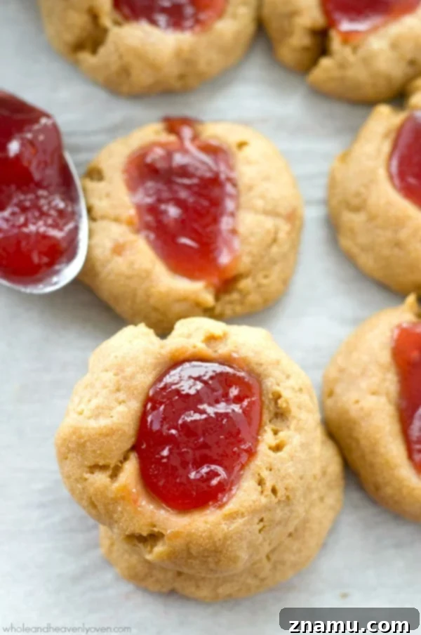 Buttery Shortbread Jam Impressions 6 Warm jam shortbread thumbprint cookies, with rich strawberry jam overflowing slightly, fresh out of the oven.