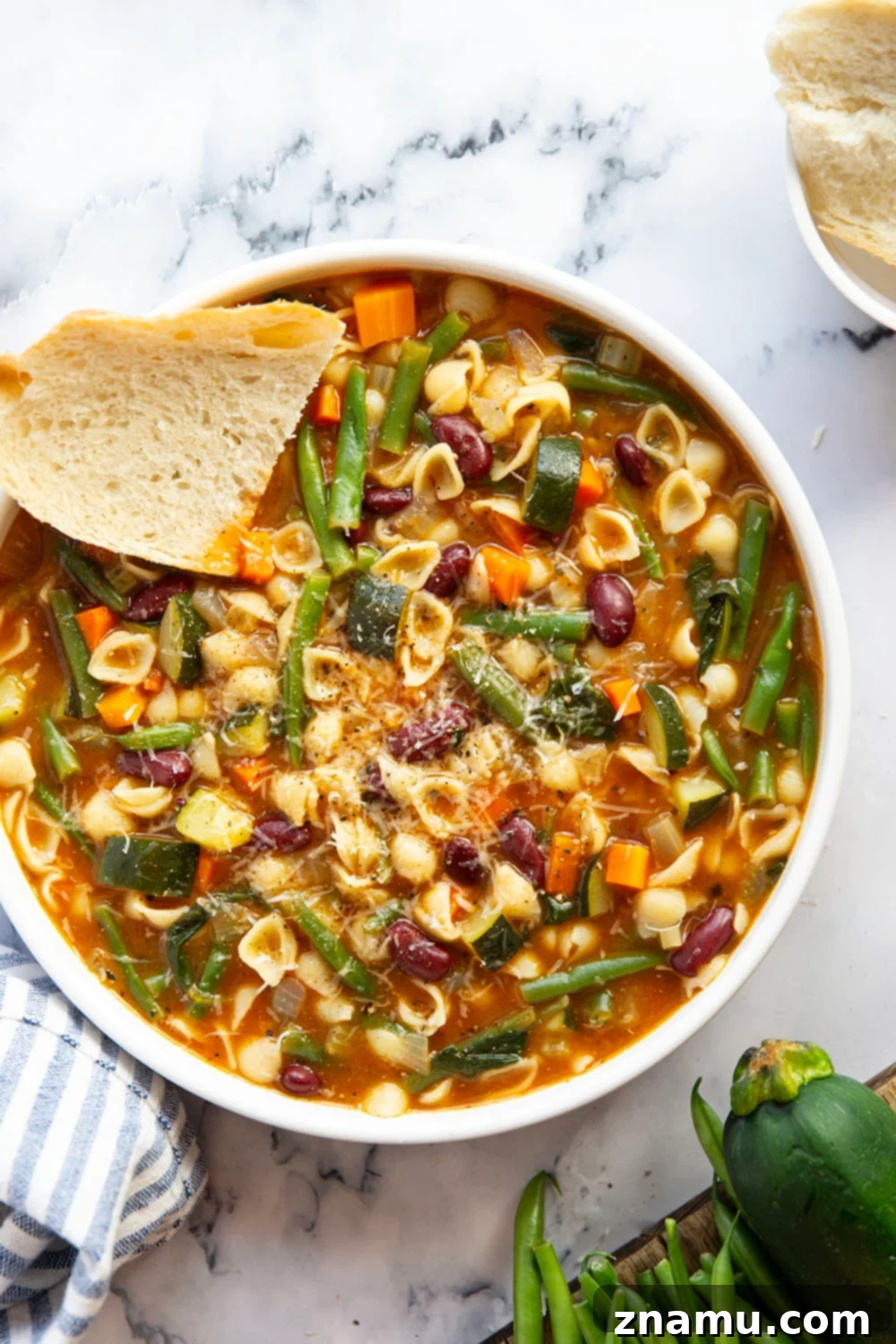 Hearty Vegetarian Minestrone 2 A vibrant, hearty bowl of vegetarian minestrone soup with fresh vegetables, beans, and pasta, garnished with fresh herbs and Parmesan.