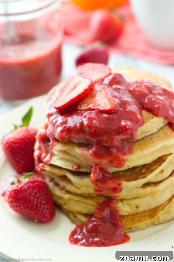 Zesty Orange Greek Yogurt Pancakes crowned with Roasted Strawberry Compote 2 Stack of moist and fluffy orange Greek yogurt pancakes with roasted strawberry sauce and fresh orange slices on top, ready for breakfast or brunch.