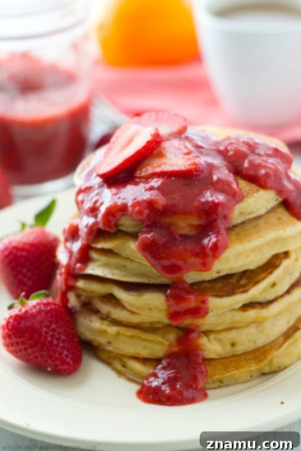 Zesty Orange Greek Yogurt Pancakes crowned with Roasted Strawberry Compote 5 Close-up of a single orange Greek yogurt pancake, showing its thick and fluffy interior texture, ready to soak up delicious sauce.