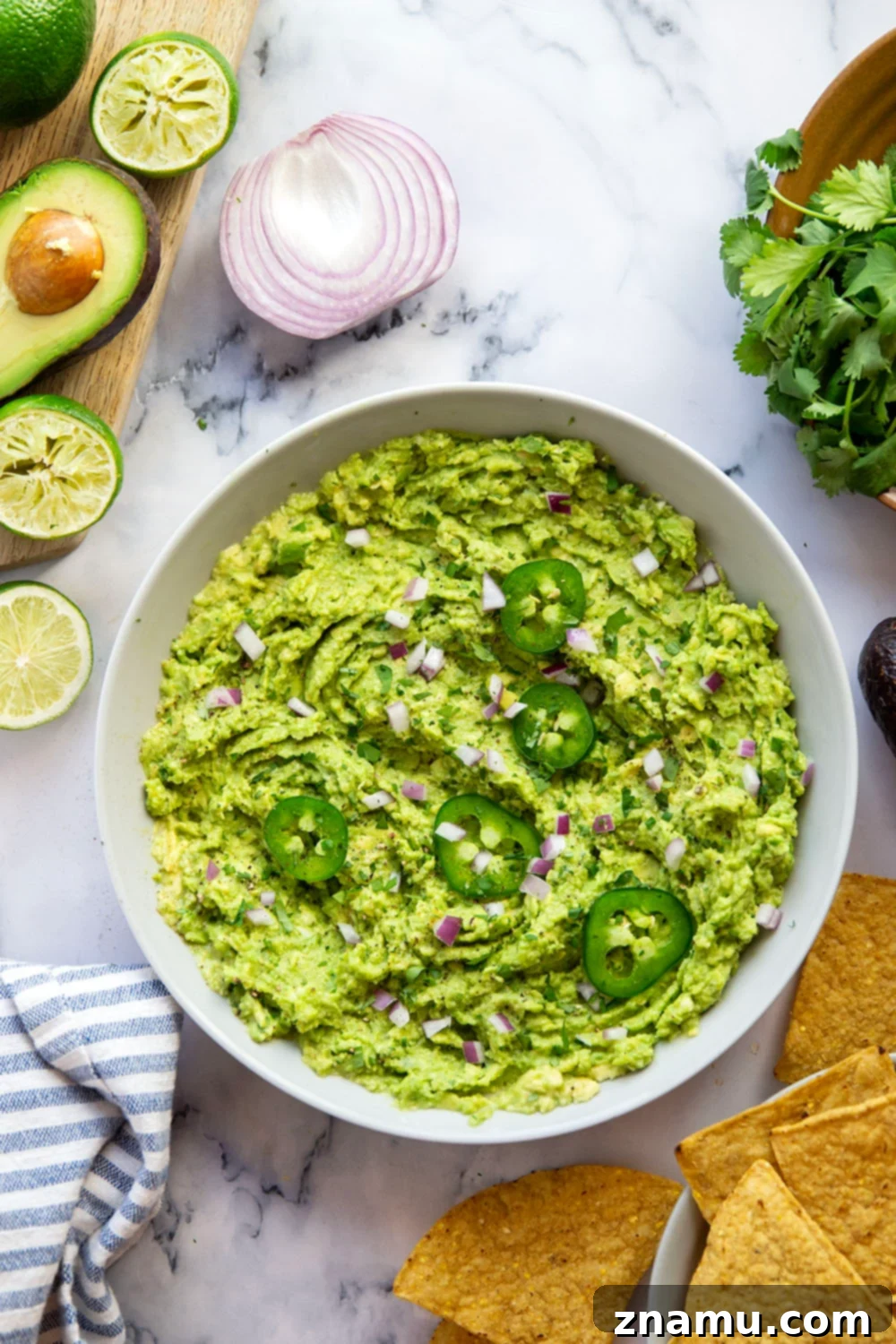 The Ultimate Guacamole Recipe 3 Close-up of freshly made guacamole with lime wedges and cilantro, ready to be served.