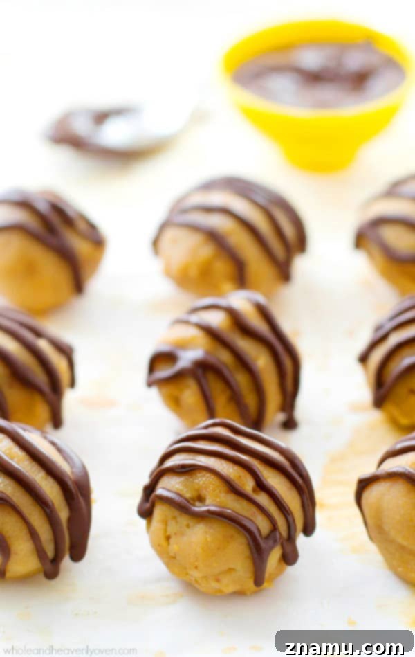 Wholesome Peanut Butter Bliss Balls 6 A hand reaching for a Healthy No-Bake Peanut Butter Cup Truffle, highlighting their irresistible nature and perfect serving size.