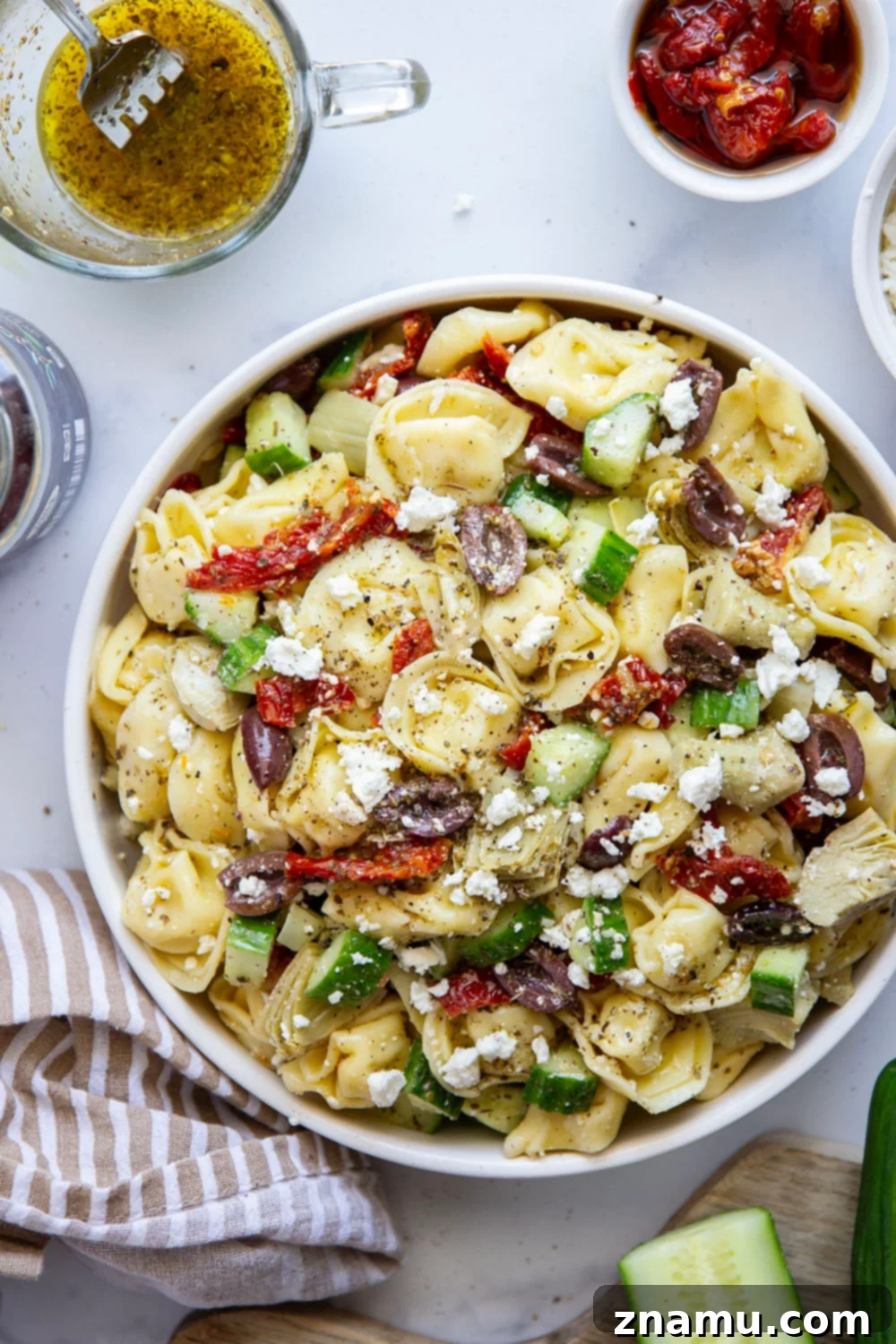 Vibrant Mediterranean Tortellini Pasta Salad 5 Various Mediterranean tortellini pasta salad ingredients in separate bowls before mixing.