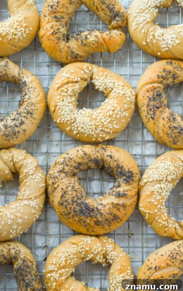 Authentic Homemade Deli Bagels 2 A perfectly golden-brown homemade bagel sliced in half, revealing its soft and chewy interior, ready to be toasted and enjoyed with a spread.