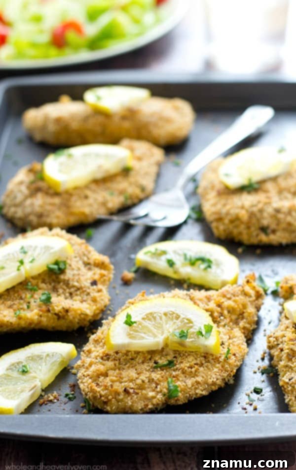 Irresistible Lemon-Garlic Crusted Chicken Tenders 3 Close-up of freshly baked, crunchy chicken tenders on a baking sheet, ready to be served.