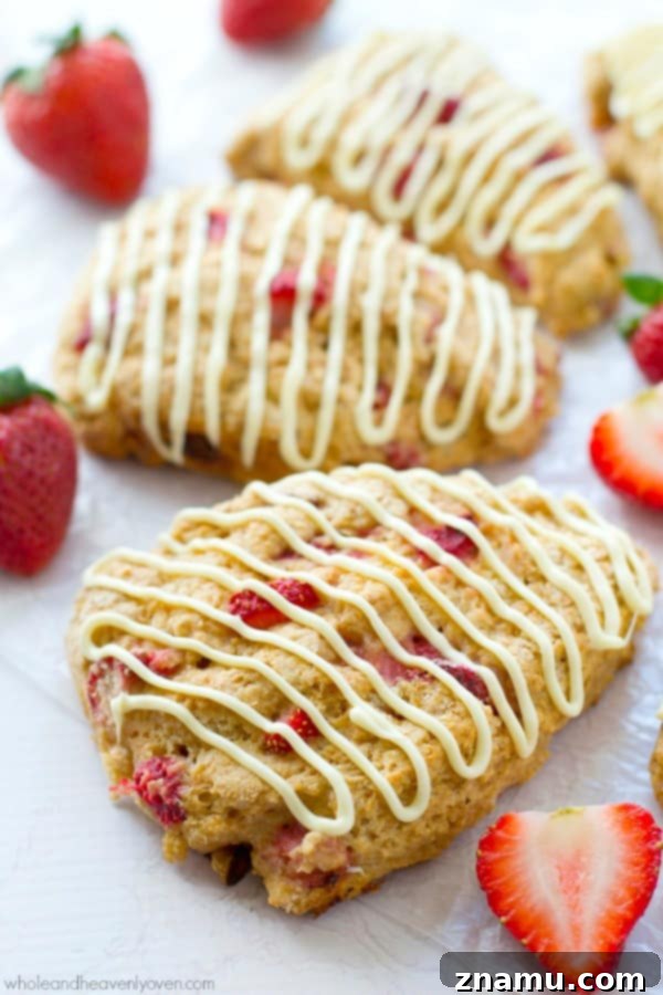 White Chocolate Strawberry Cream Scones 7 Hand-held white chocolate strawberry scone, featuring a delightful texture and inviting appearance