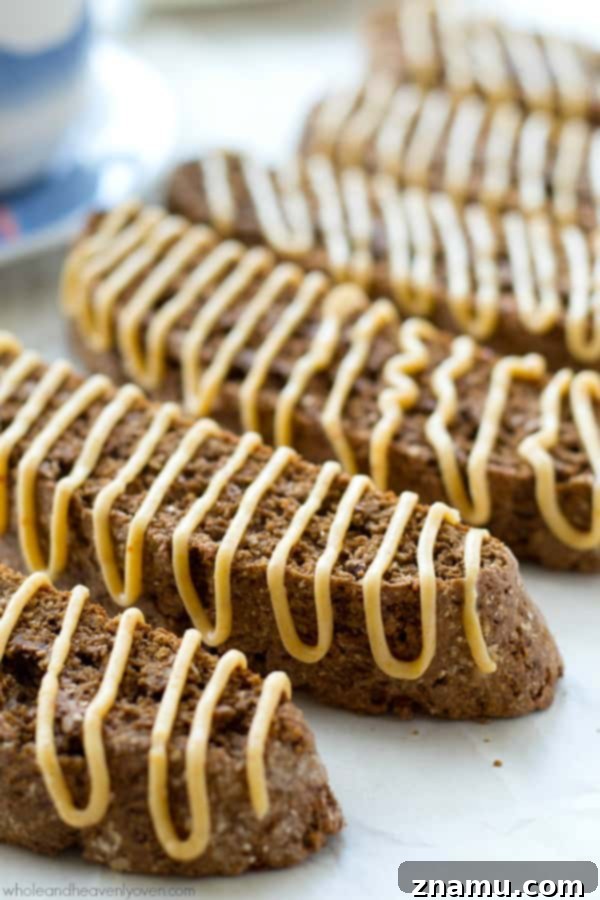 A stack of rich chocolate biscotti, artfully arranged and coated in a decadent peanut butter glaze, irresistible for any time of day.