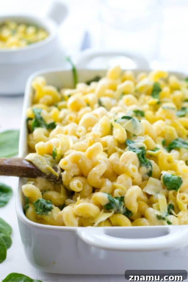 Creamy Spinach Artichoke Mac n Cheese 2 Creamy Spinach Artichoke Dip Mac and Cheese, freshly baked in a dish