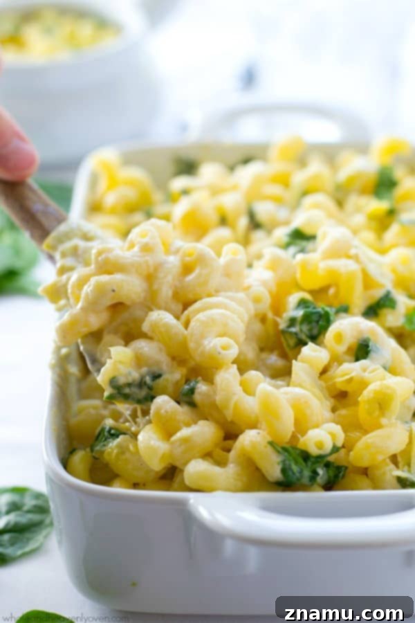 Creamy Spinach Artichoke Mac n Cheese 5 A generous serving of Spinach Artichoke Mac and Cheese on a white plate