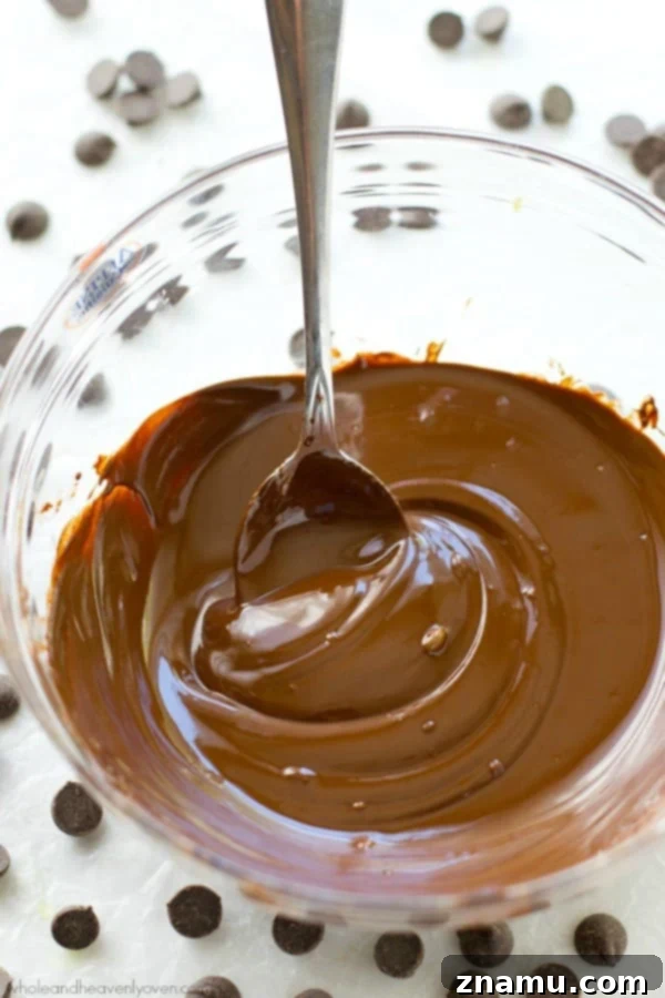 Mastering the Art of Chocolate Melting 3 A close-up shot of chocolate pieces in a glass bowl, ready to be melted over a pot of simmering water.