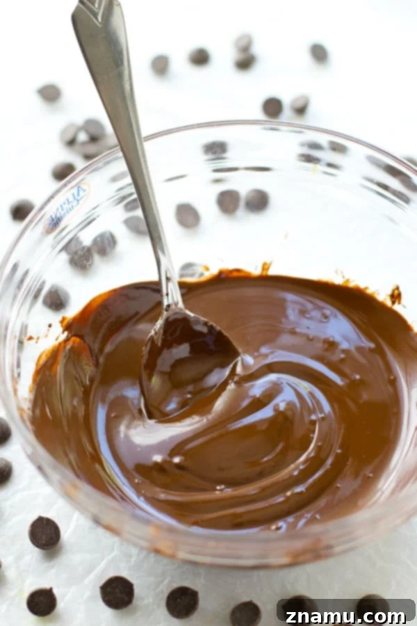 Mastering the Art of Chocolate Melting 4 Overhead view of chopped chocolate in a bowl, steam rising gently from the saucepan below.