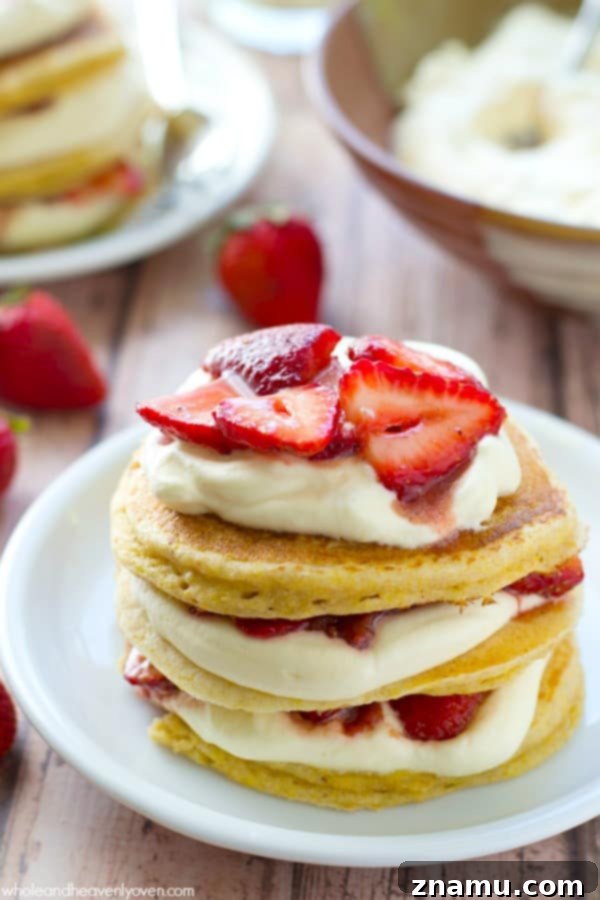 Cloud-High Strawberry Pancakes 4 Close-up of a stacked strawberry shortcake pancake tower