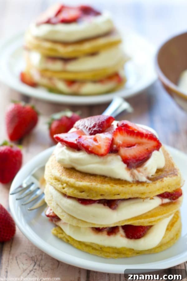 Cloud-High Strawberry Pancakes 6 A towering stack of strawberry shortcake pancakes ready to serve