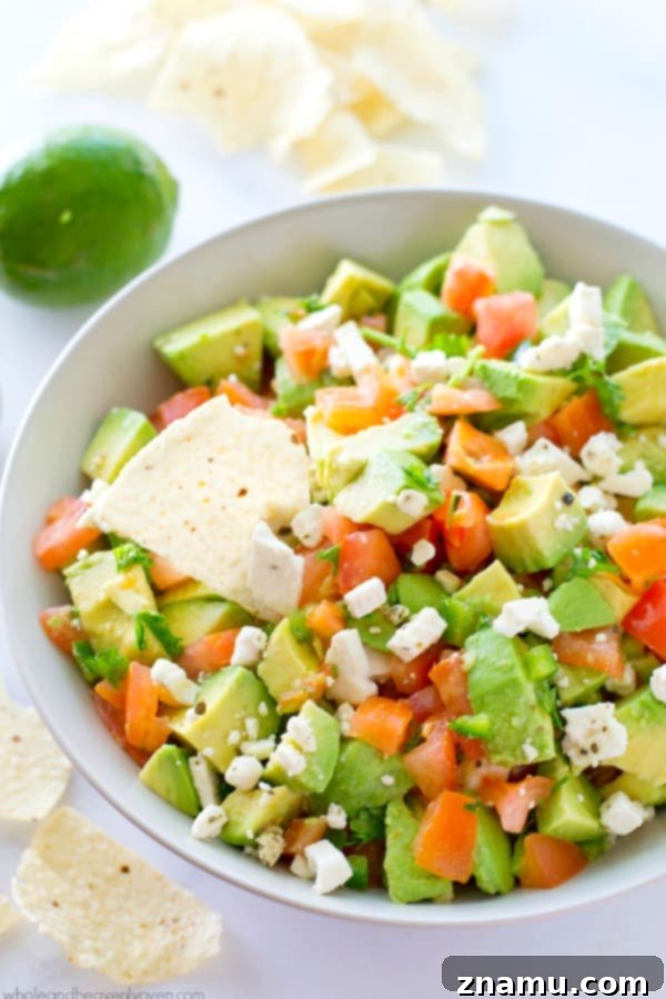 Robust Mediterranean Guacamole 4 Close-up of Chunky Greek Guacamole, showcasing feta, tomatoes, and avocado