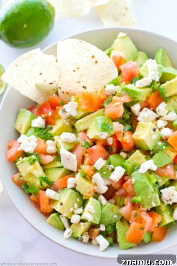 Robust Mediterranean Guacamole 6 A vibrant bowl of Chunky Greek Guacamole with fresh lime wedges