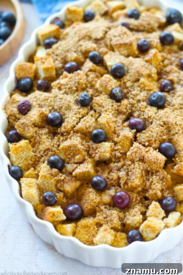 Baked Blueberry Streusel French Toast Bliss 3 Close-up of a golden-brown overnight blueberry french toast bake, showing the moist interior, plump blueberries, and crumbly streusel topping.