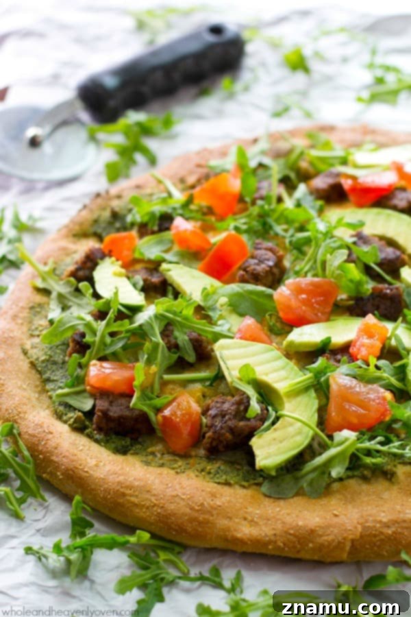 California Pesto Cheeseburger Pizza 6 A full, vibrant California-style veggie burger pesto pizza, ready to be sliced and served.