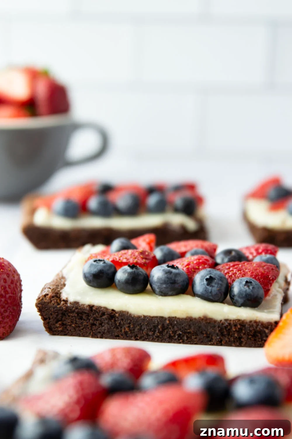 Red, White & Blue Brownie Pizza 4 Overhead shot of the 4th of July brownie dessert pizza, showcasing the artful arrangement of strawberries and blueberries over the white cream cheese frosting, creating a flag-like design.